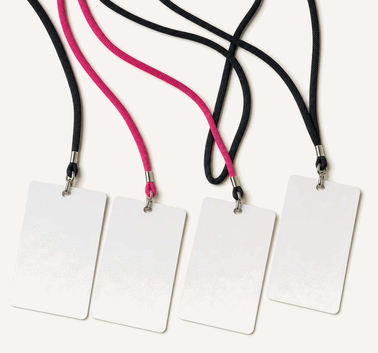 Four blank laminated passes lying in a fanned row, each on its own lanyard cord, three cords black and one magenta.