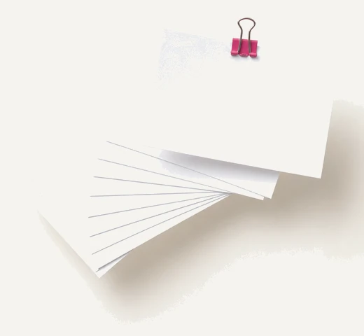 Ten blank index cards fanned in a loose arc, one lifted above the rest by a small magenta clip.