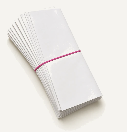 A stack of blank folded paper flyers fanned across each other and bound with a single magenta rubber band.
